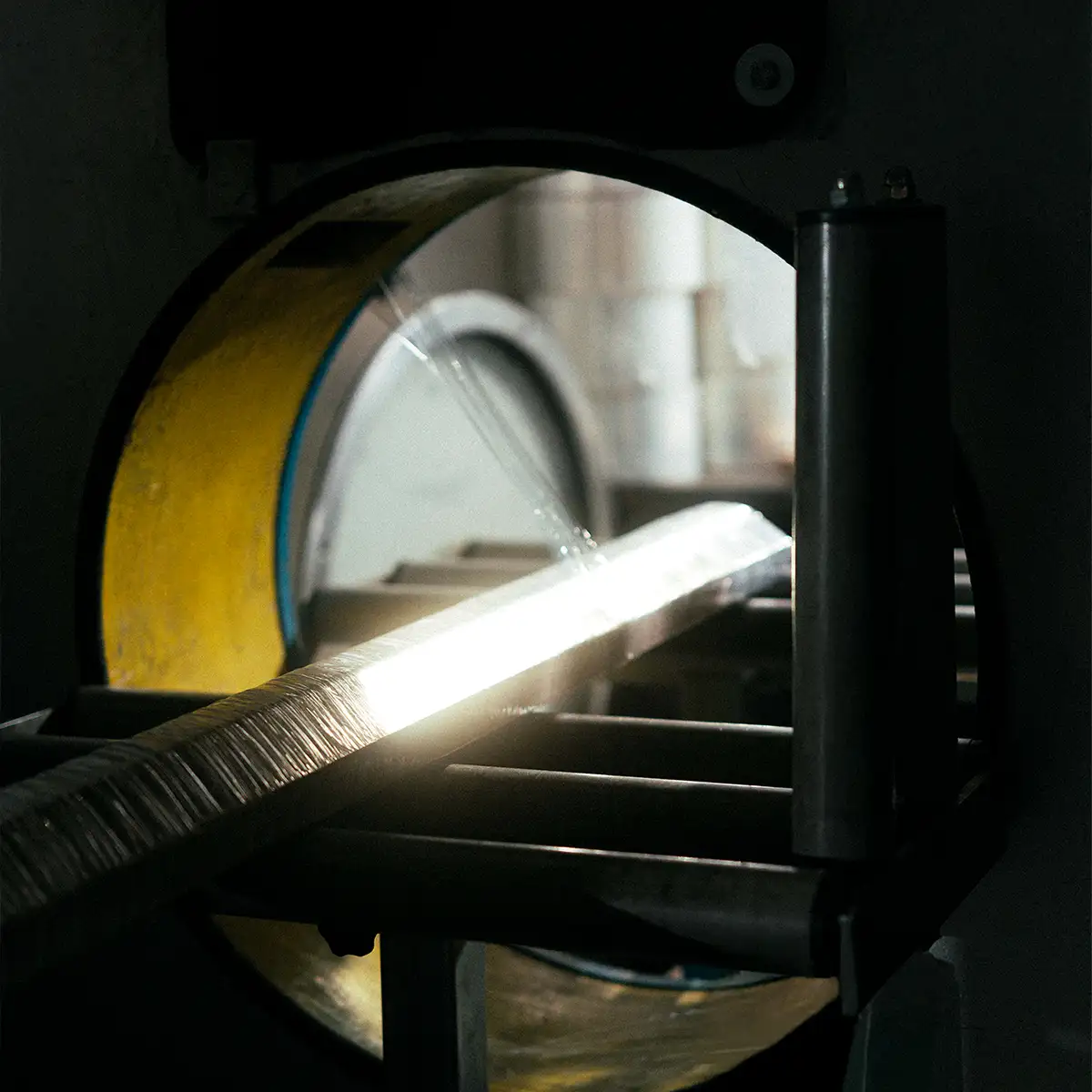 Metallstäbe werden in einer Einwickelmaschine verpackt.