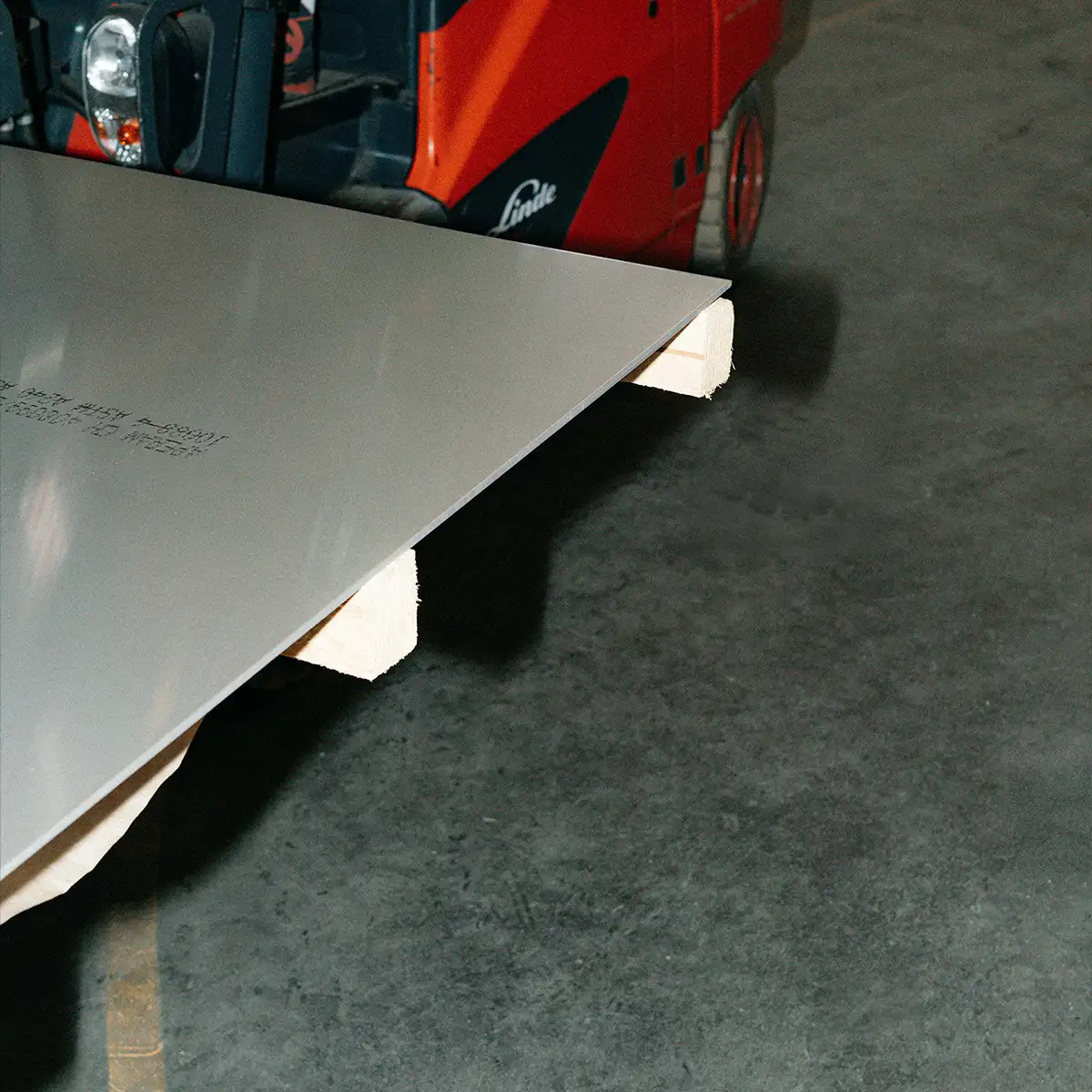 Große Metallplatte wird mit einem Gabelstapler transportiert.