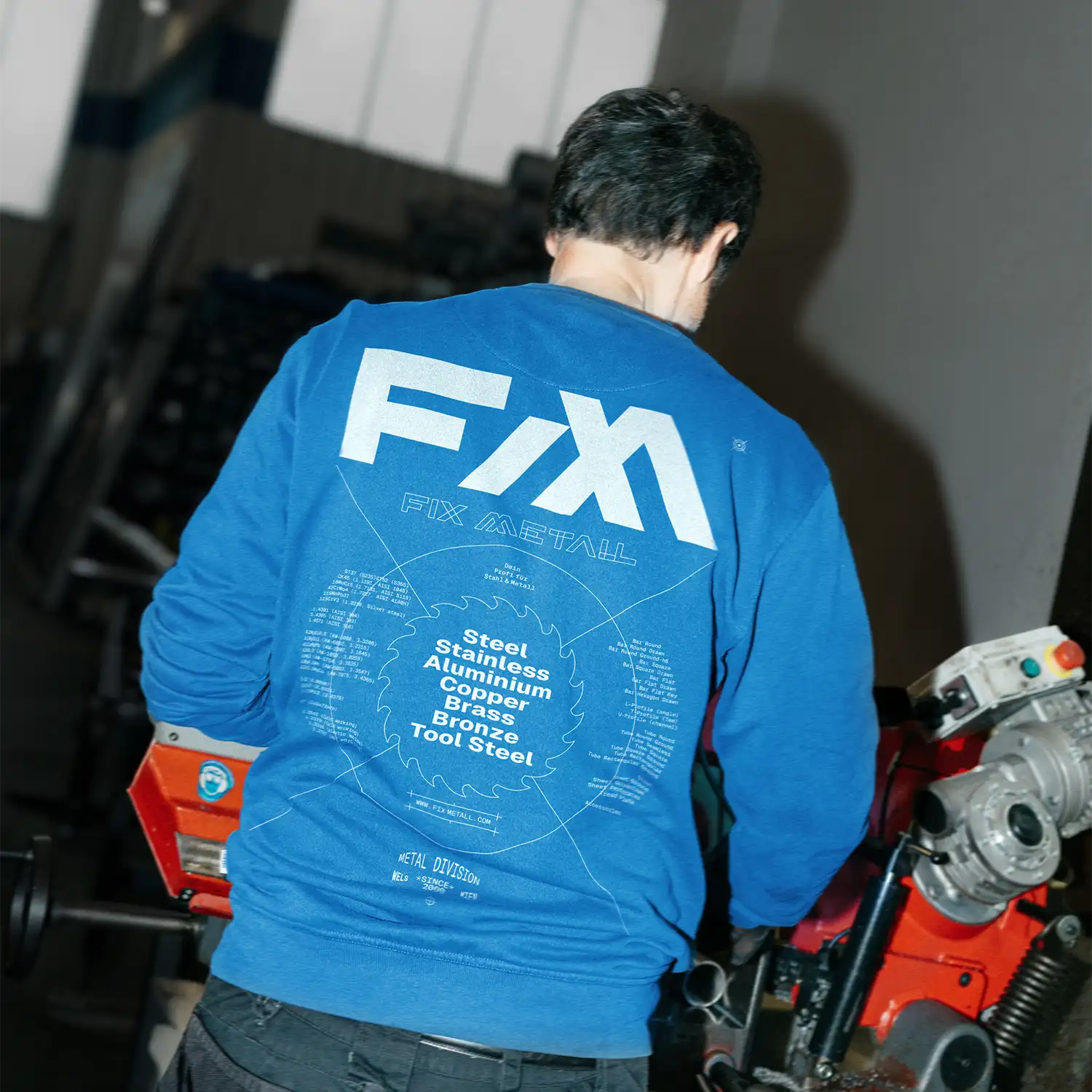Person trägt blauen Pullover mit 'FIX METALL' Aufdruck.